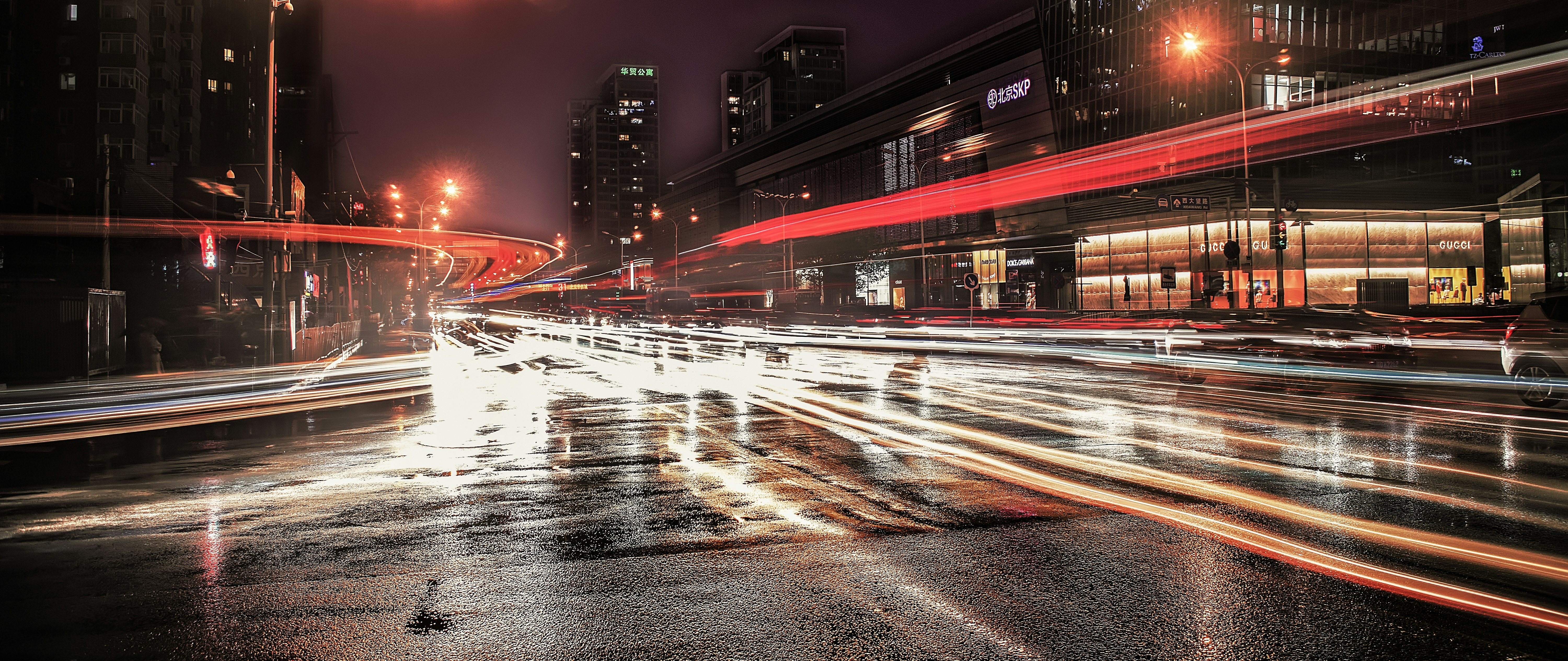 asphalt road with lights beside high-rise buildings during nighttime